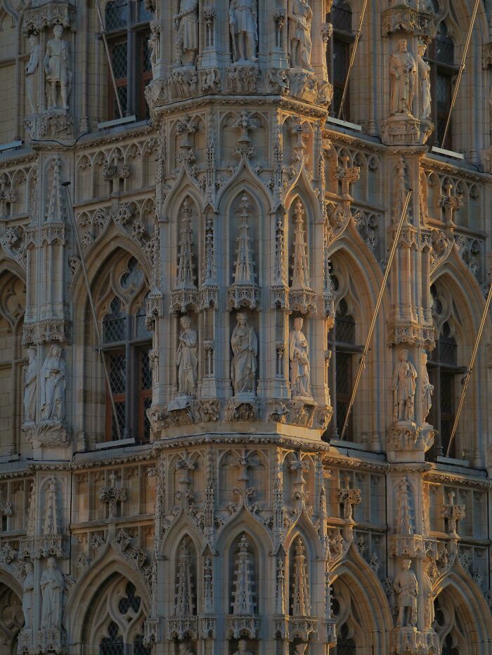 Gothic architectural feat with intricate stone carvings and statues decorating an impressive historic building facade.