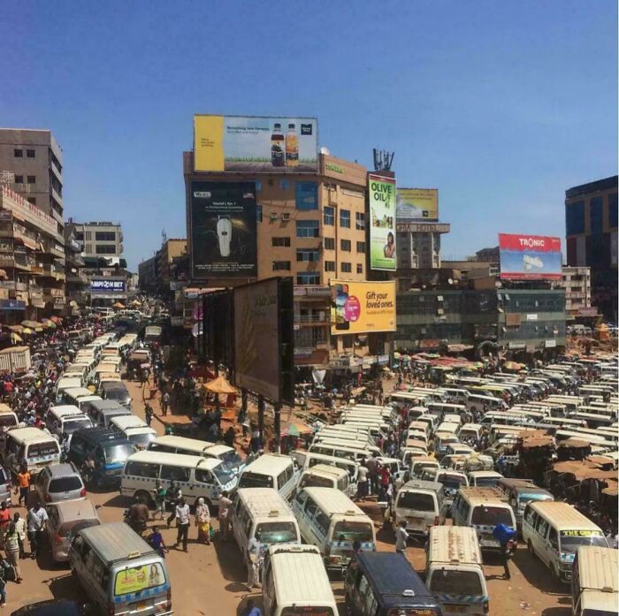 Urban hell scene with heavy traffic and crowded streets under a clear sky.