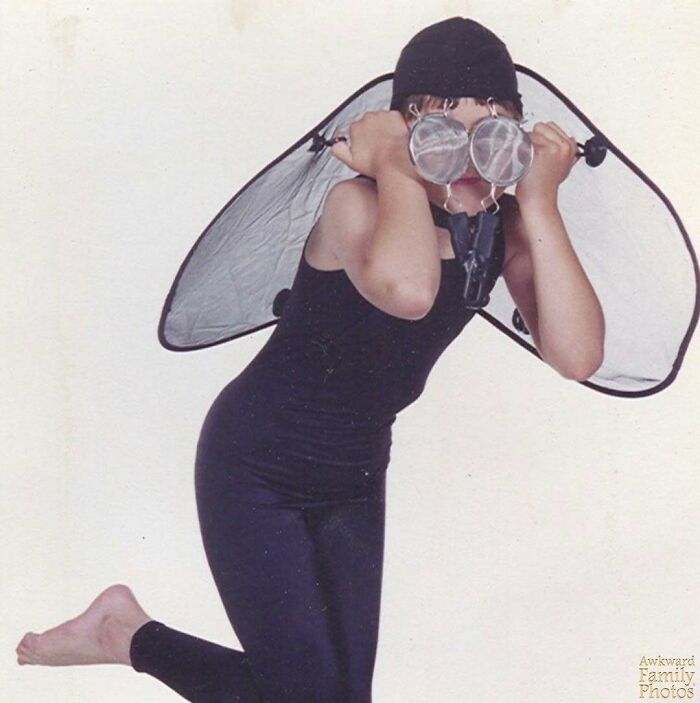 Child in fly costume posing playfully, embodying awkward family photo vibes.