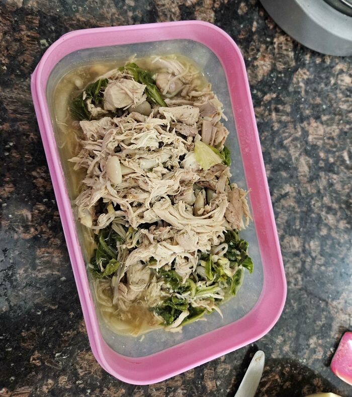Unappetizing meal with shredded meat and wilted greens in a pink container, highlighting horrible-roommates.