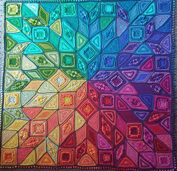 Colorful crocheted blanket with intricate geometric patterns.