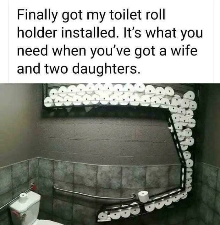 Dad humor with a huge toilet roll holder installation, captioned humorously about having a wife and two daughters.