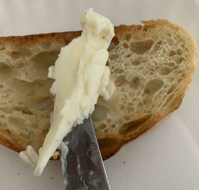 Butter resembling a face on bread slice, showcasing pareidolia pictures.