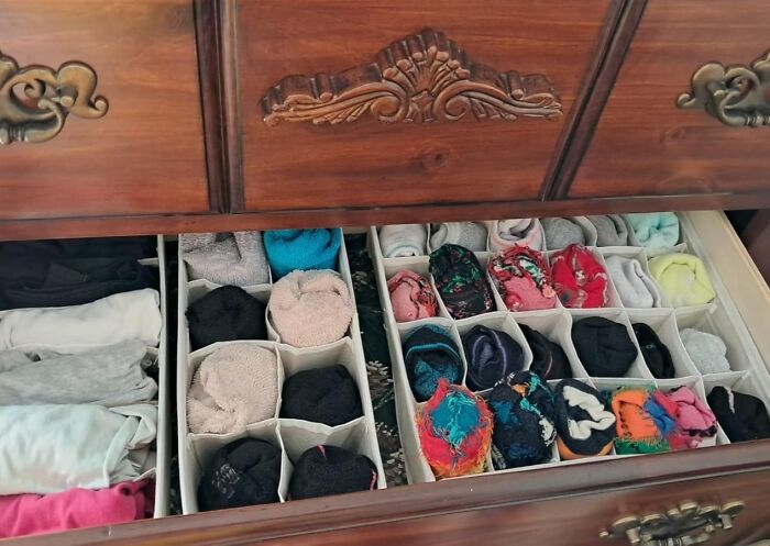 Wooden drawer neatly organized with rolled clothes and dividers for operation clean life organization ideas.
