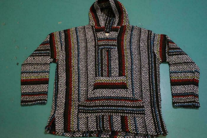 Vintage 80s woven hoodie with colorful stripes on a teal background, representing 80s nostalgia fashion.