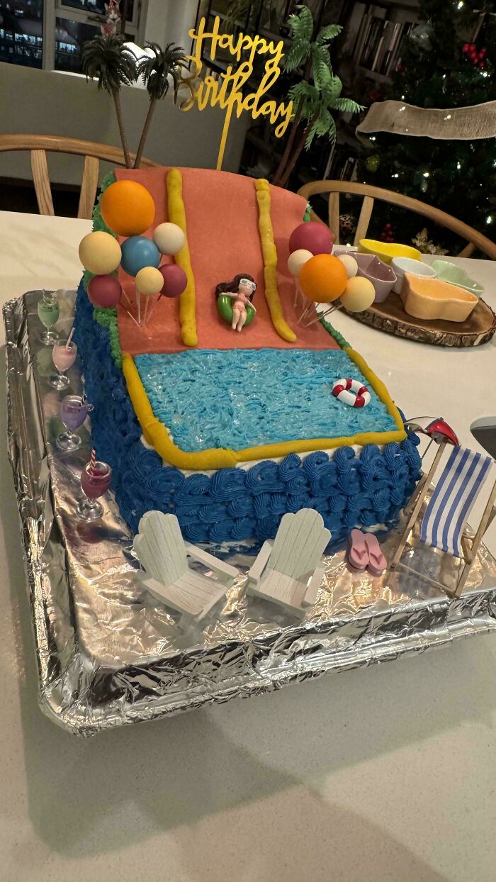 Impressive cake with waterslide design, featuring colorful balloons and a pool, showcasing advanced baking creativity.