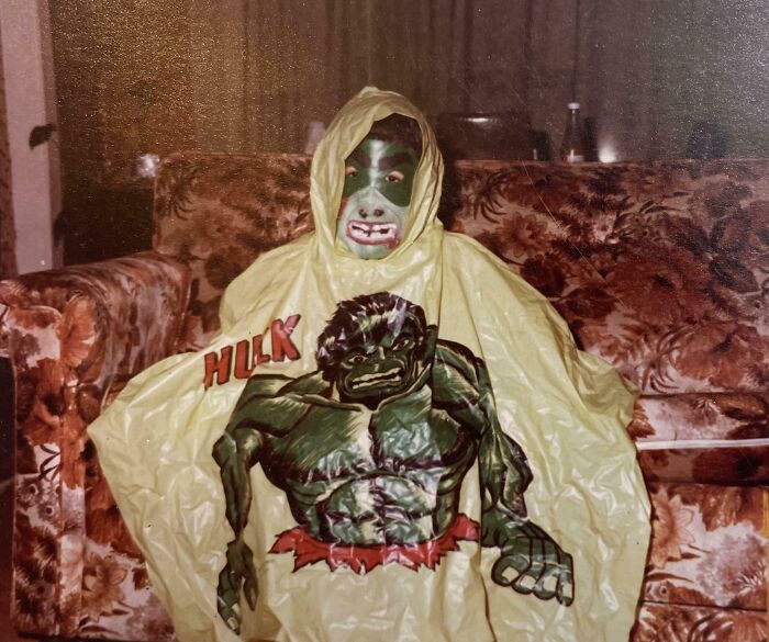 Child in '80s Hulk costume sitting on a vintage floral couch, embodying 80s nostalgia pictures.