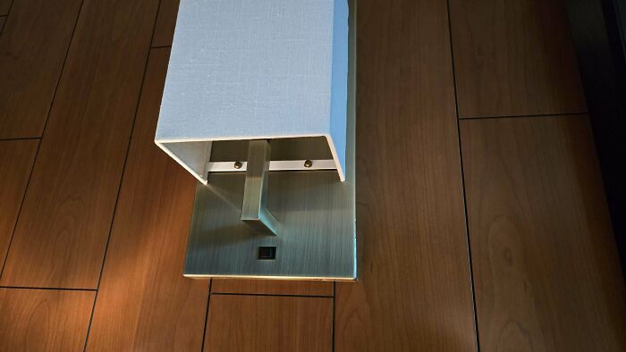 A lamp resembling a face on a wooden floor, showcasing pareidolia.