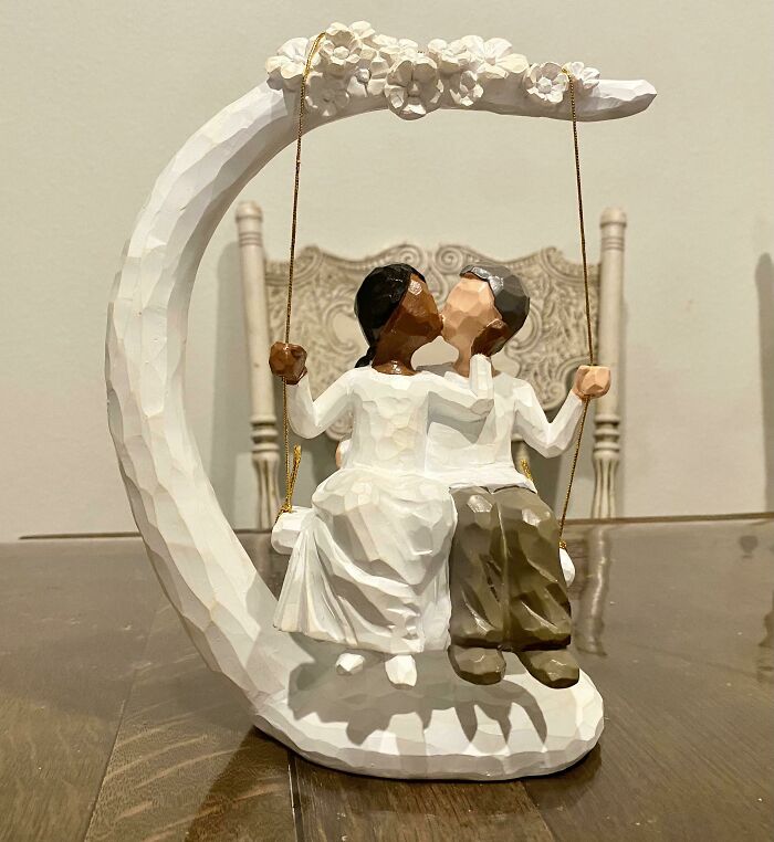 Wooden figurine of a couple on a swing, perfect for funny wholesome anniversary surprises.