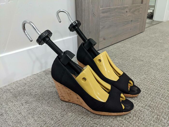 Black wedge shoes with yellow clamps as a funny wholesome anniversary surprise.