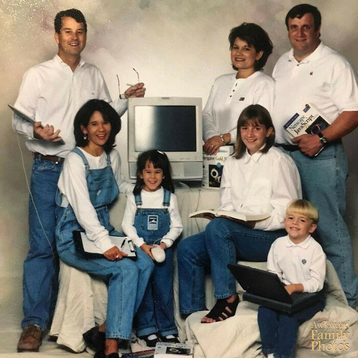 Family posing with vintage computers in awkward family photo that feels incredibly sweet and nostalgic.
