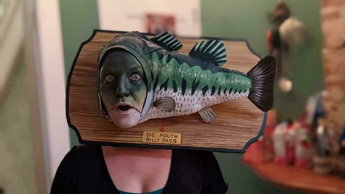 Person wearing a creative DIY Big Mouth Billy Bass costume with a fish head around their face, standing in a room.