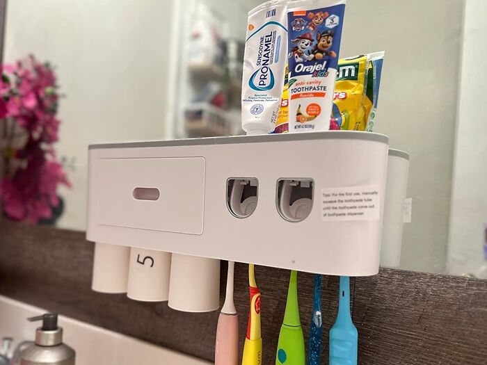Toothbrush holder with colorful brushes and toothpaste, promoting a responsible start to the New Year in bathroom decor.