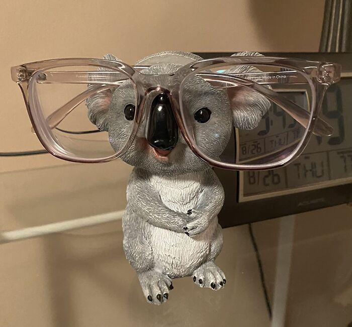 Koala figurine wearing glasses, showcasing fun office supplies on a desk.