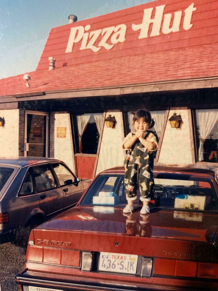 Child standing on a car in front of a vintage Pizza Hut, evoking strong 80s nostalgia pictures.