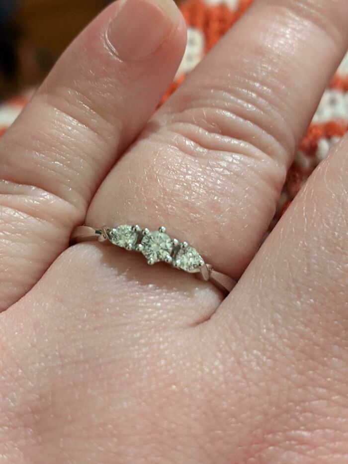 Close-up of a hand wearing a diamond ring, symbolizing funny wholesome anniversary surprise.