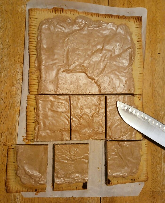 A large pop tart being sliced into squares, showcasing a creative baking creation.