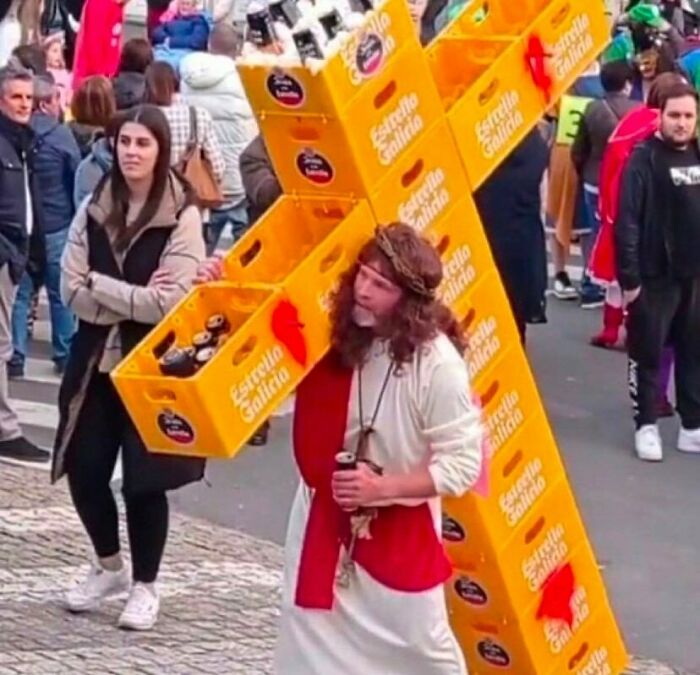 Hombre disfrazado cargando cajas de cerveza Estrella Galicia, imagen divertida que hace reír a mucha gente en evento público.