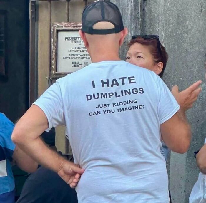 Man wearing a humorous shirt about hating dumplings, talking to a woman outside.