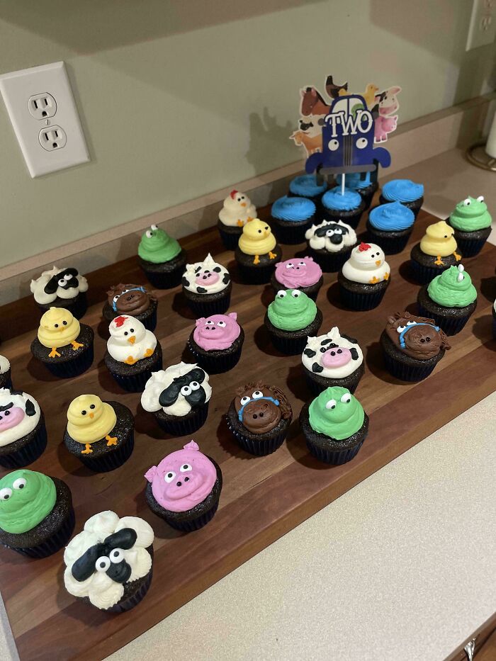 Colorful animal-themed cupcakes creatively displayed for a second birthday party.