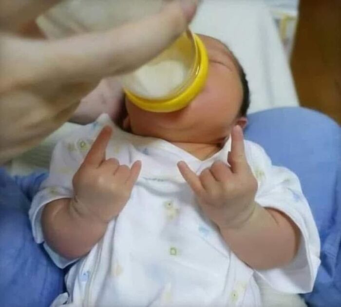 Baby drinking from bottle making rock hand gestures; IG page weirdness post.