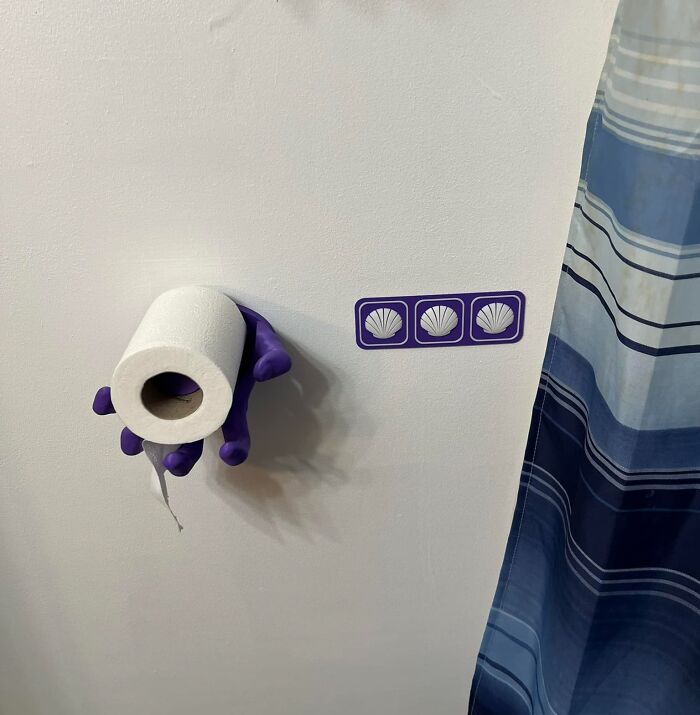 Gen X humor with a purple hand holding toilet paper, referencing three seashells by a shower curtain.