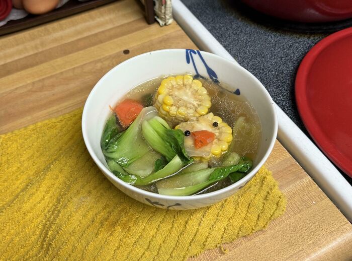 Bowl of soup with veggies resembling a duck, showcasing pareidolia.