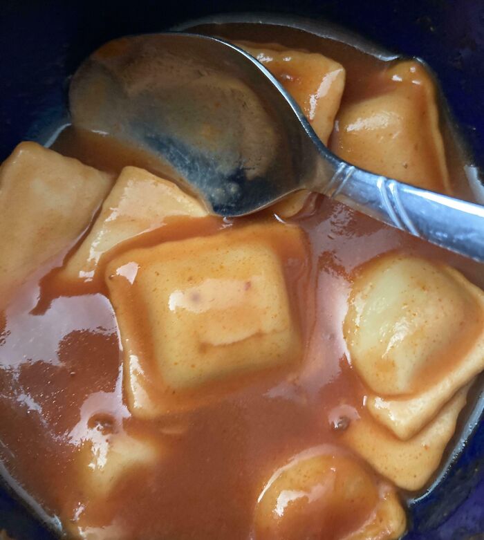 Ravioli in sauce resembling a smiling face, illustrating pareidolia.