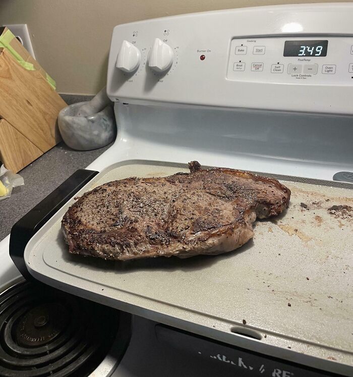Grilled steak on a stove resembling a face, illustrating pareidolia-pictures.