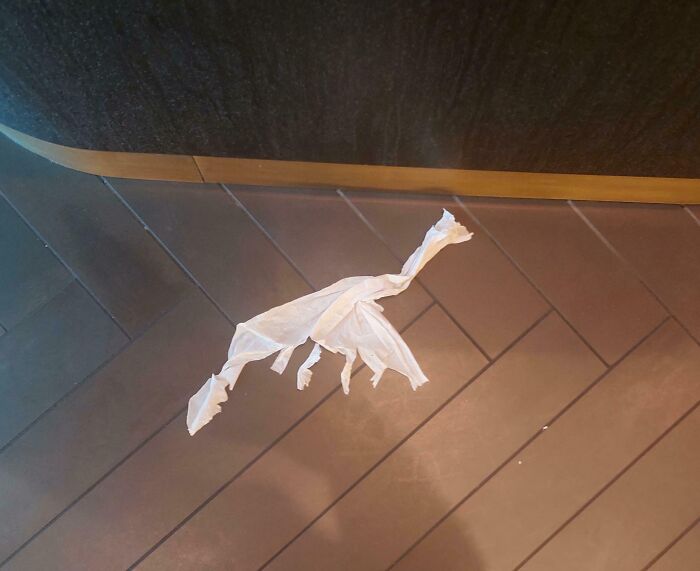 A crumpled tissue on the floor resembling a dinosaur shape, demonstrating pareidolia-pictures.