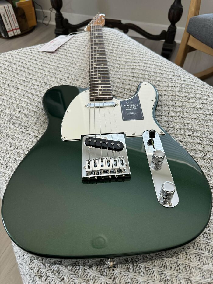 Green electric guitar on a knitted blanket, perfect for funny wholesome anniversary surprises.