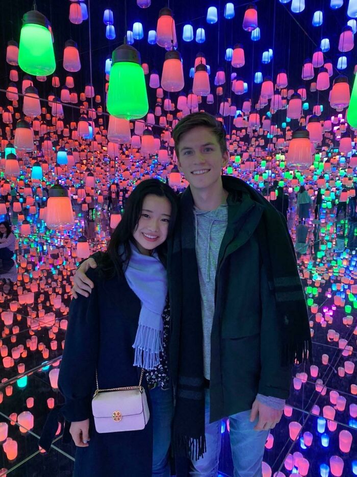 Couple embracing in a colorful, vibrant lantern display, symbolizing long-distance love.