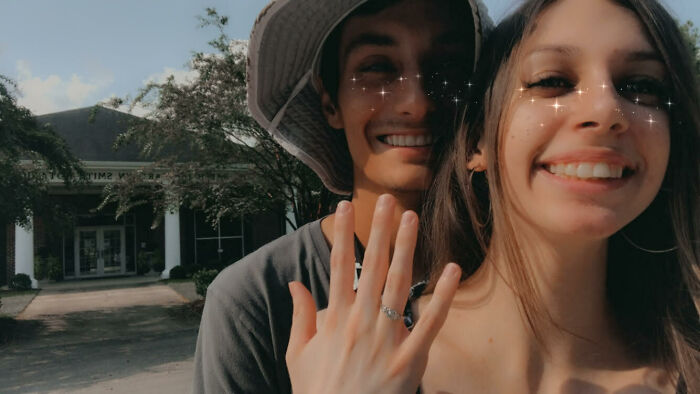 A smiling couple showing an engagement ring, symbolizing long-distance love success.