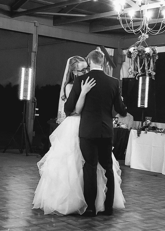 Bride and groom embracing on the dance floor, symbolizing enduring long-distance love.