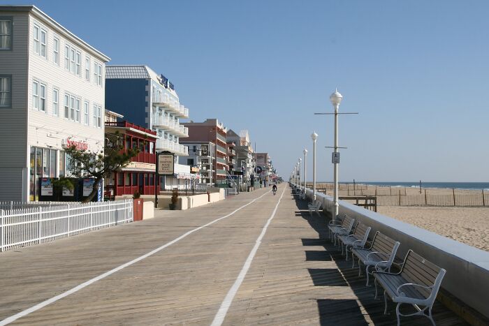 Boardwalk along the beach with benches and buildings, showcasing amazing views in states.