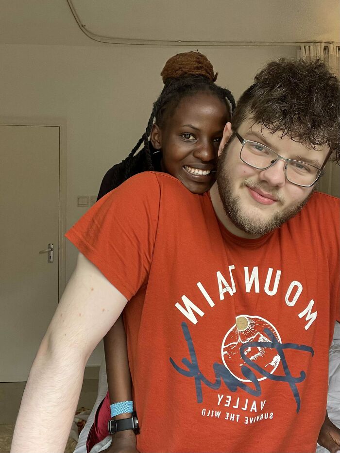 A couple smiling and embracing, demonstrating enduring love in a cozy room setting.