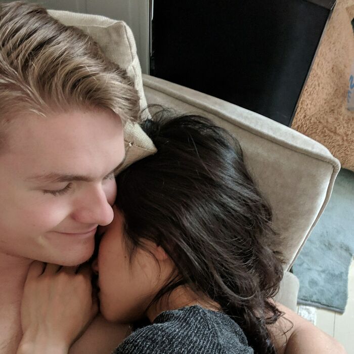 Couple snuggling on a couch, illustrating long-distance love.