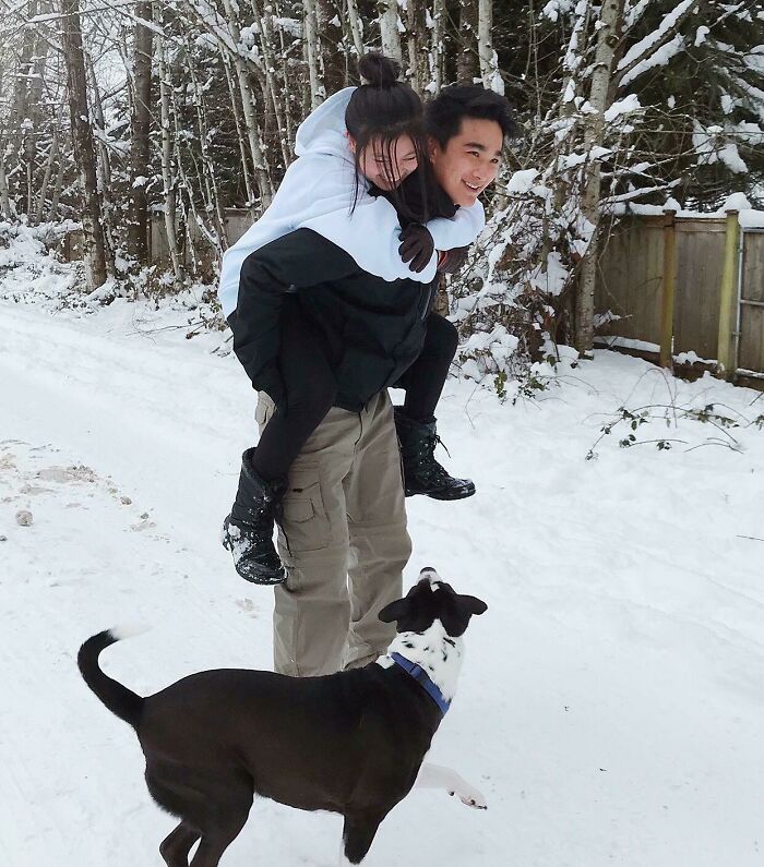 Couple in snowy landscape with dog, showcasing long-distance love's strength.