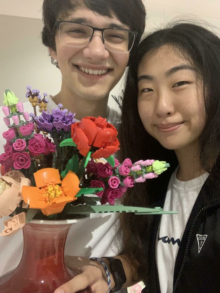 Couple smiling with a colorful bouquet, embodying long-distance love.