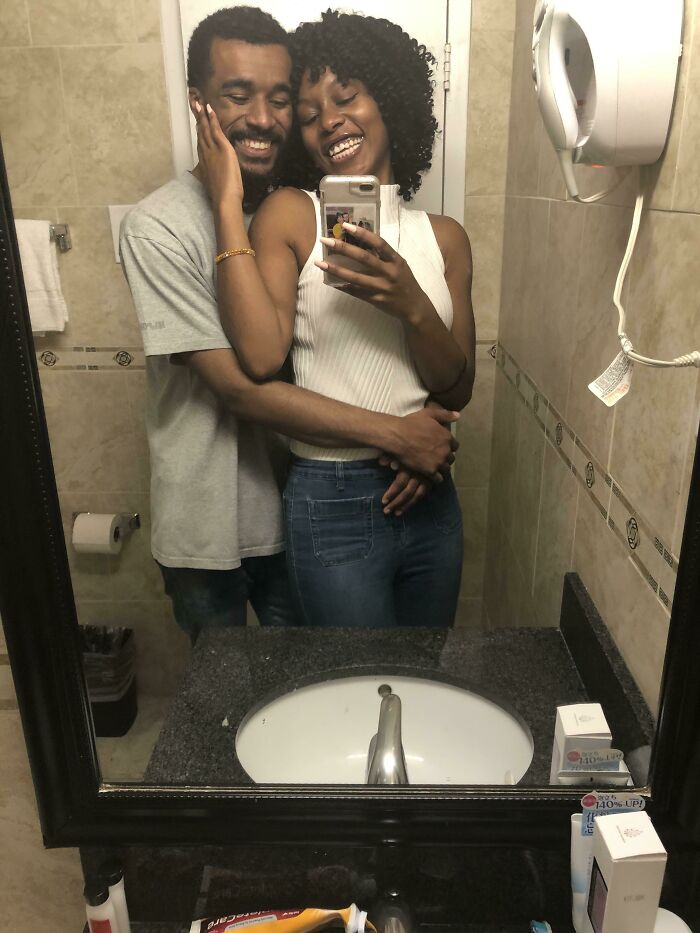 A happy couple taking a selfie in the bathroom, embodying long-distance love.