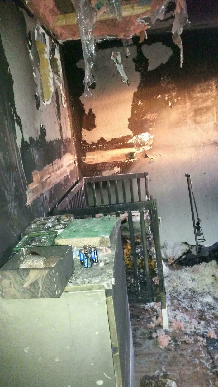 Fire-damaged room with melted ceiling insulation and charred walls, illustrating nature disaster resilience challenges.