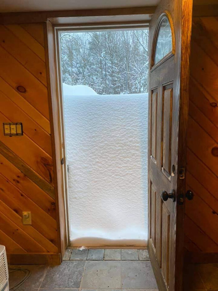 Door opens to deep snow, illustrating nature disaster resilience in a snowy forest setting.