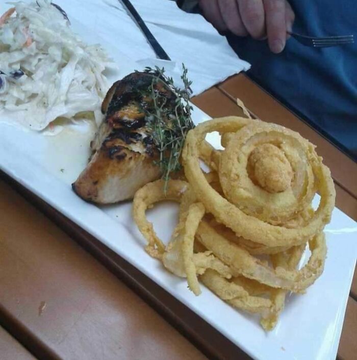 Grilled chicken with herbs, onion rings resembling a spiral illusion, and coleslaw, reflecting Pareidolia-Pictures theme.