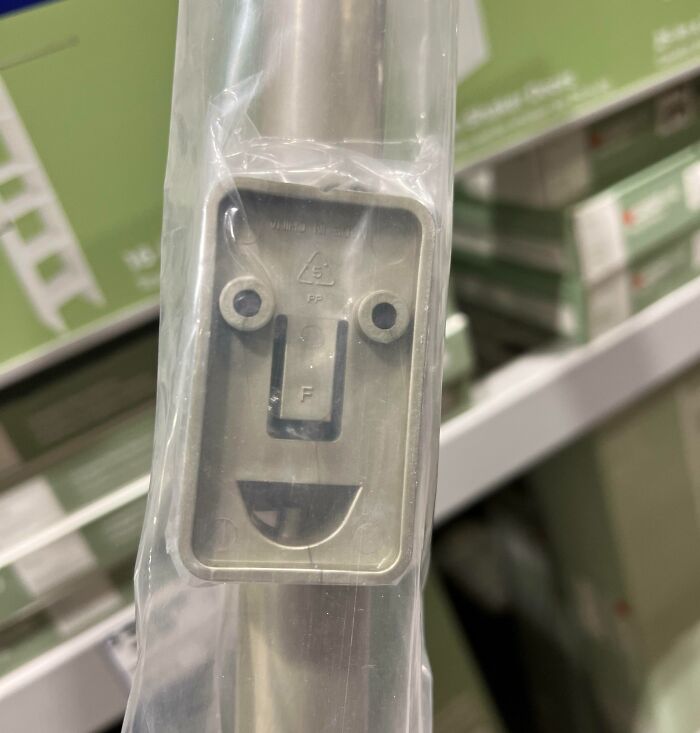 Metal bracket with a face-like appearance wrapped in plastic, illustrating pareidolia-pictures in a store setting.