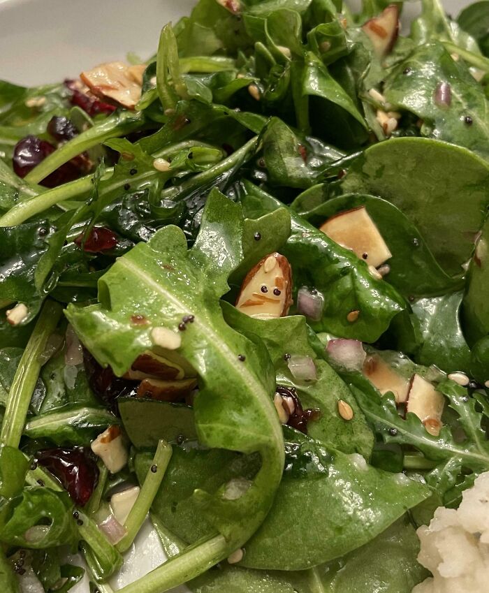 Leafy salad features pareidolia with a face-like almond among the greens.