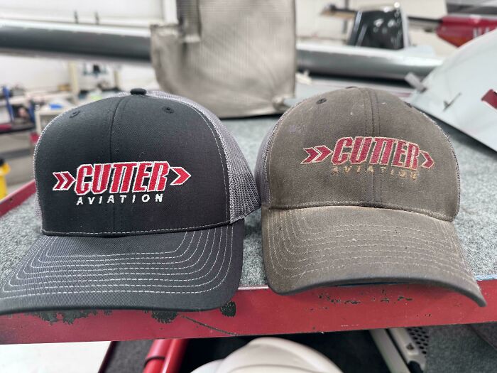 Two Cutter Aviation caps, one new and one worn-down, illustrating the effects of time.