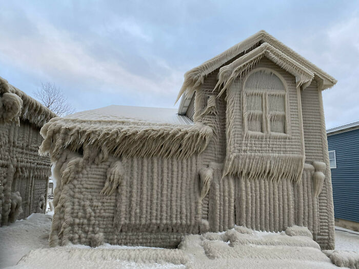 Frozen house covered in ice, illustrating nature disaster resilience amid extreme winter conditions.