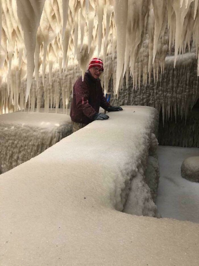 Person in a frozen cave with icicles demonstrating nature disaster resilience.