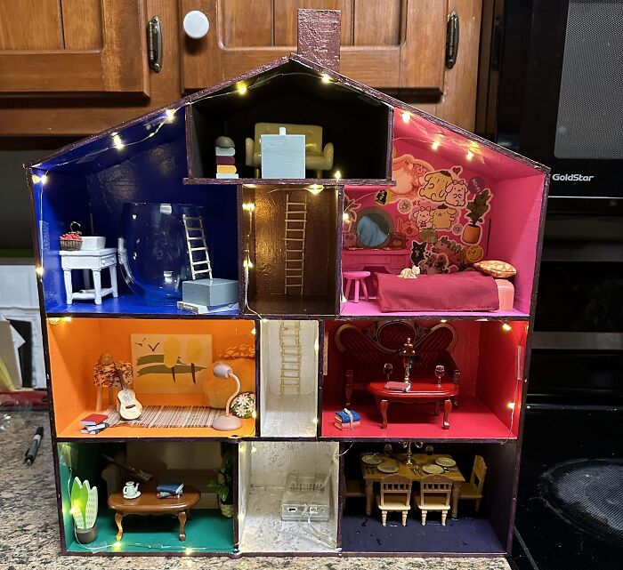 Miniature dollhouse with colorful rooms, decorated with whimsical furniture and LED lights for a funny wholesome anniversary surprise.
