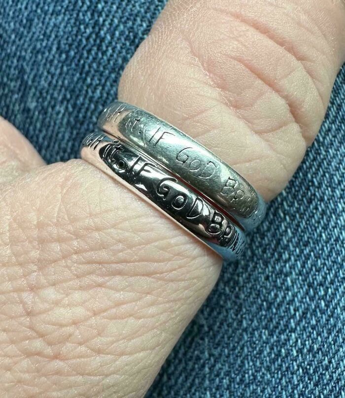 Two worn-down silver rings on a finger, illustrating how time affects objects, with faded inscriptions visible.